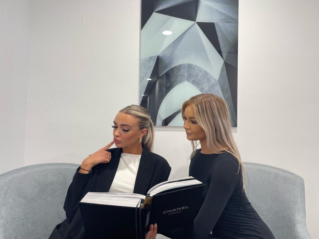 two women looking a brochure in office